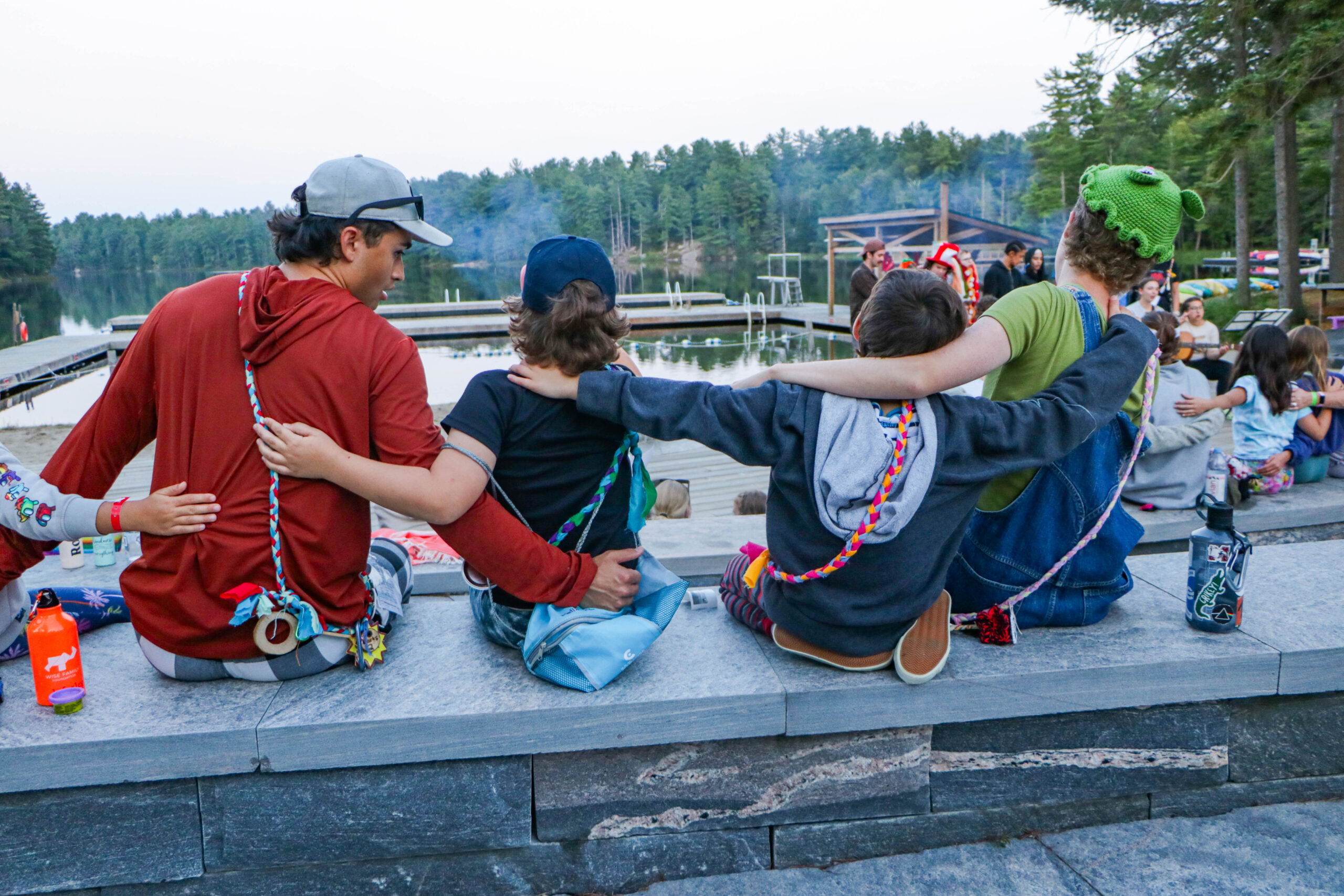 campers and volunteers sitting together around the campfire at camp