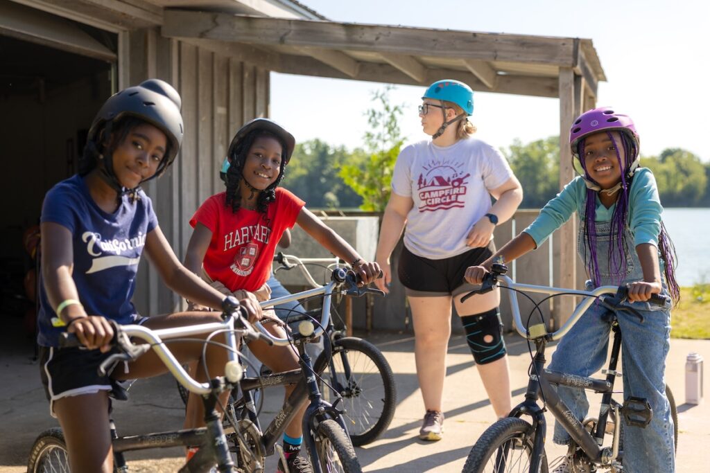 campers and volunteers with bikes at camp