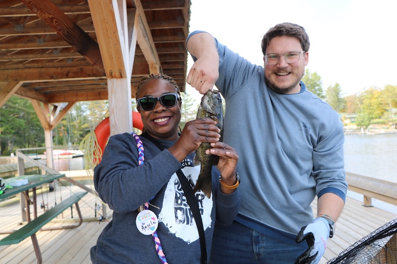 volunteers holding up fish caught at camp