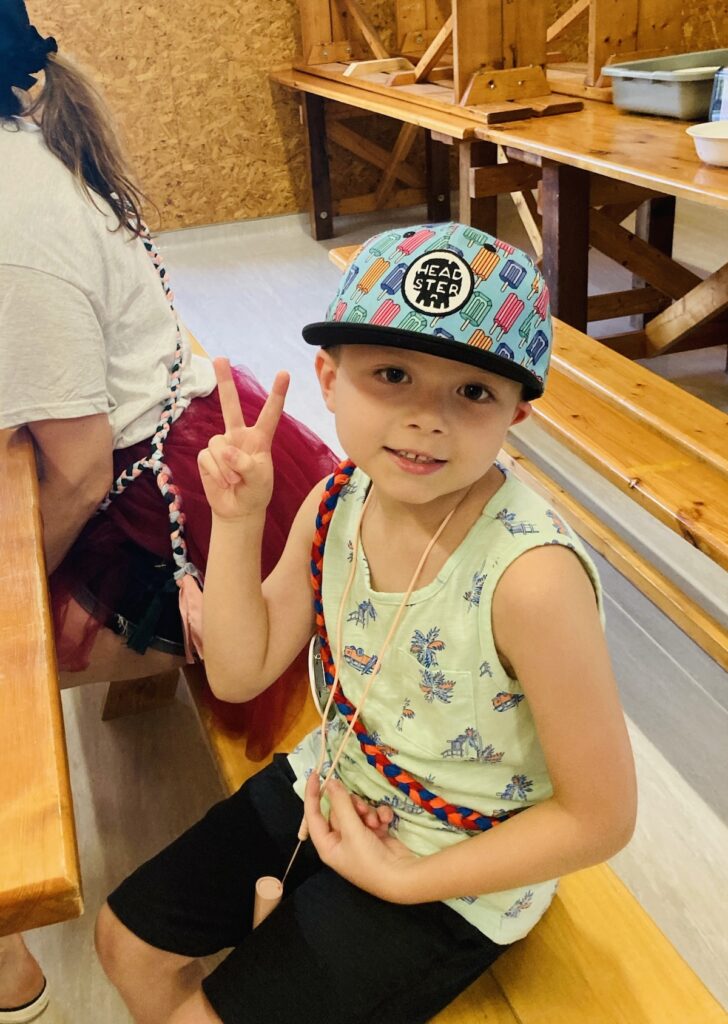 ben at camp showing a peace sign with his right hand