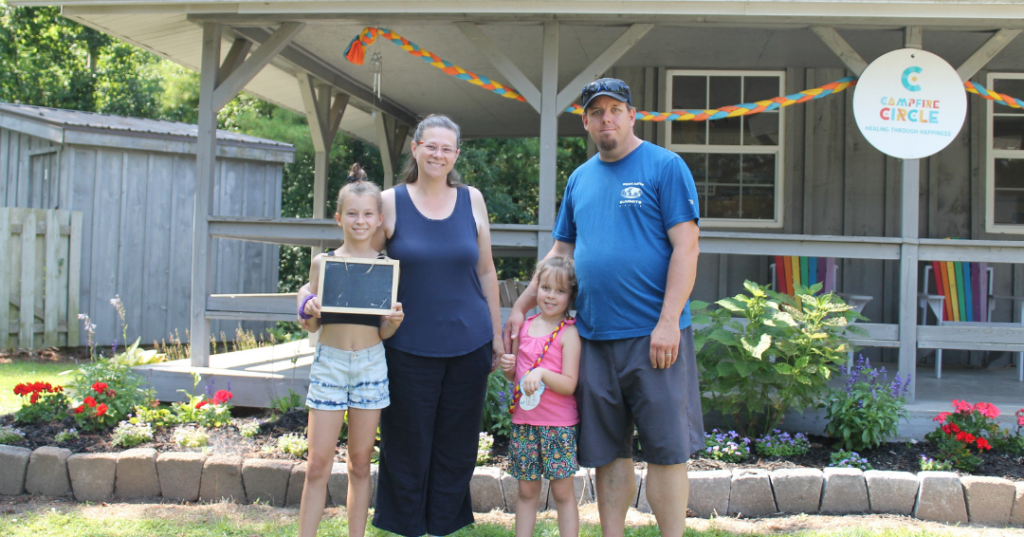 brooke and family outside cabin at camp