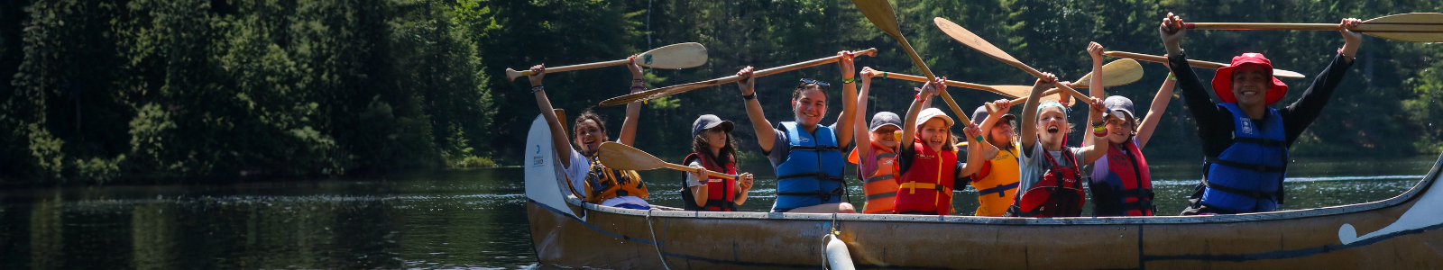campers in canoe with paddles in the air