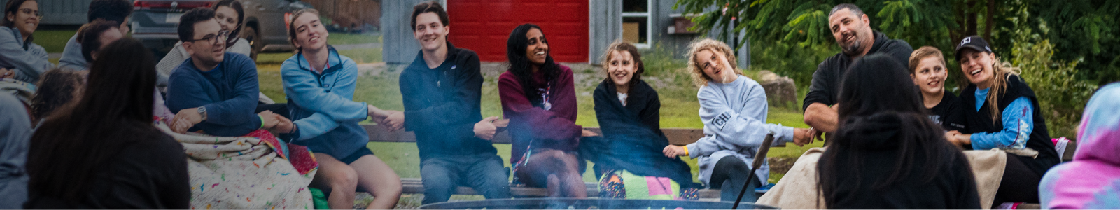 families sitting around the campfire at camp