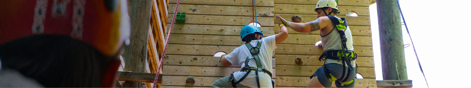 camper and counsellor on climbing wall at camp