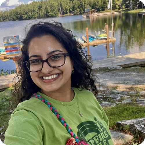 nurse armita outside at camp with lake in background